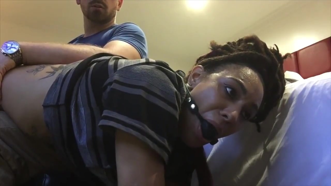 black girl has wrists zip-tied, and is ballgagged before otk spanking. poster